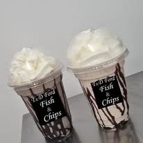 Two T & D Ford milkshakes topped with cream.